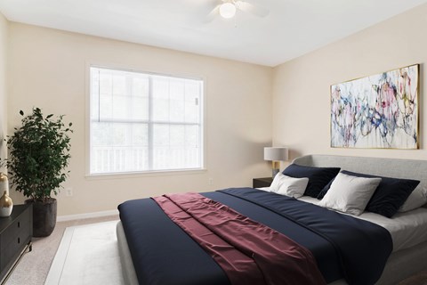 A bedroom with a large bed and a painting on the wall.